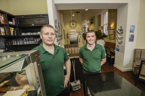 Two men behind counter in bakery