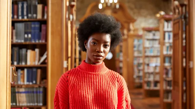 Bangor University library - person standing looking at books 