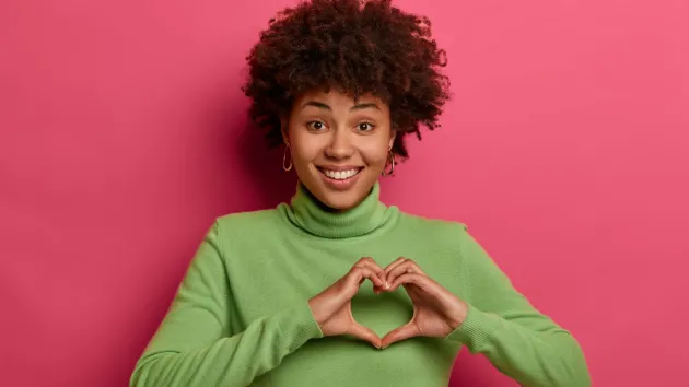 female holding her hands in a heart shape