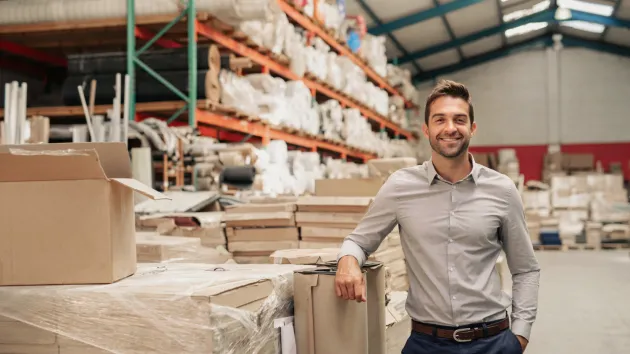 Business owner stood beside packaging