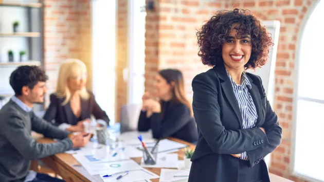 Business woman stood by a desk in an office