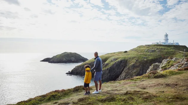 family walking near a lighthouse 