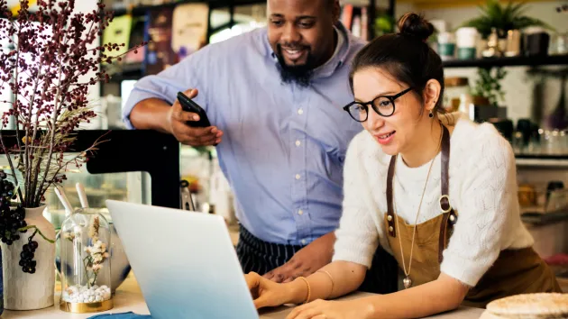 Small business owners looking at a digital device