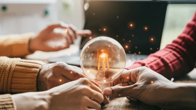 hands holding a lightbulb