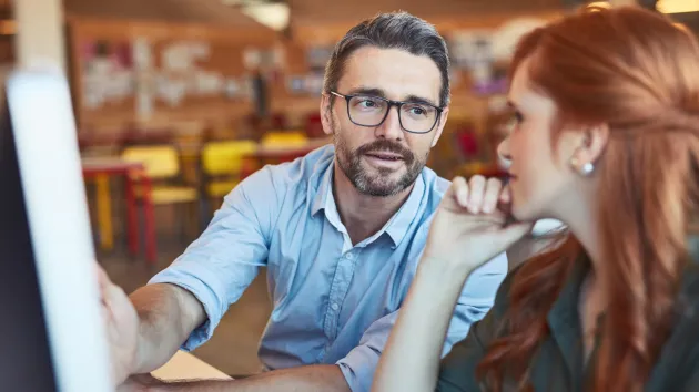 Mentor speaking to colleagues in an office 