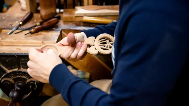 Person making a love spoon