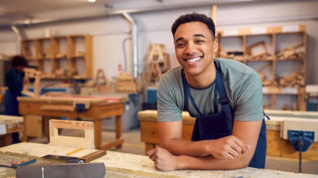 male employee leaning on a desk 