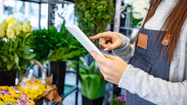 Florist looking at a digital device 