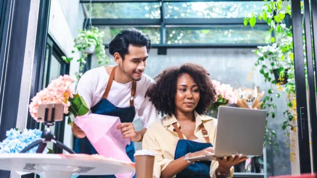 Small business owners looking at a digital device