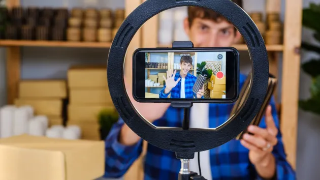 Business owner selling goods on line via mobile phone app