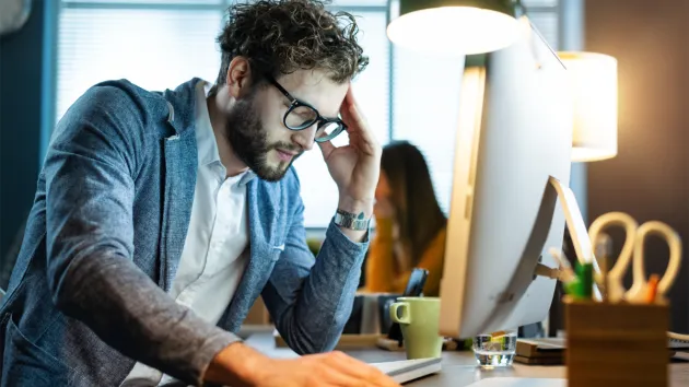 Tired employee looking at a laptop