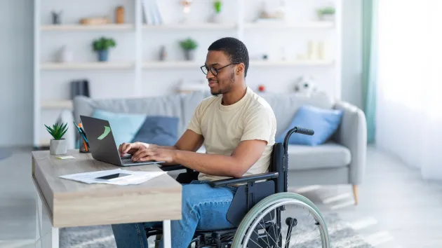 Wheelchair user, working from home using a laptop 