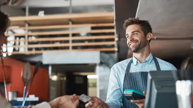 cafe worker taking payment from a customer 