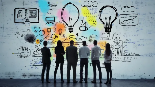 Whiteboard with colourful lightbulbs and people looking at the whiteboard 