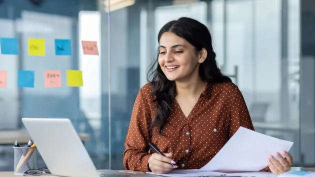 Happy smiling office worker using a laptop 