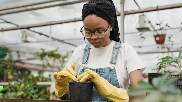 A Girl Putting Soil In A Pot