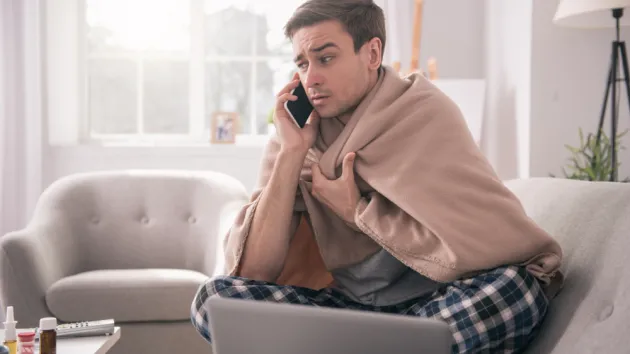 Sad young man talking on the phone to his employer while asking about the sick leave