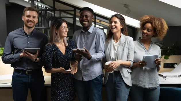  business team people laughing joking having fun standing together in modern office