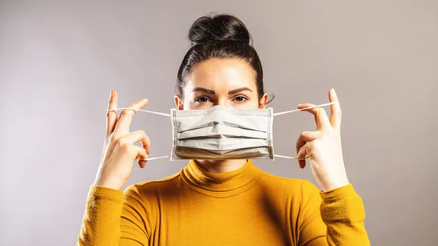 woman putting on a face mask