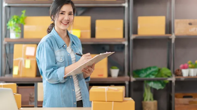  woman owner startup business look at camera work happy with box at home prepare parcel delivery in sme supply chain, procurement,