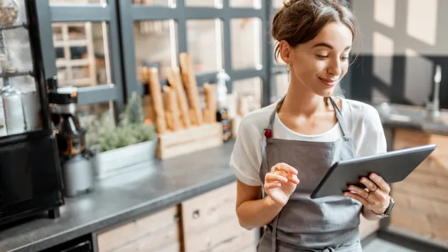 cafe owner looking at a digital device 