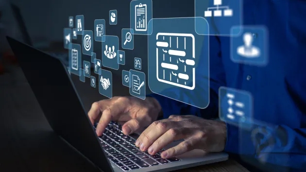 Project manager working on computer at the office. Concept with icons of management areas such as cost, planning, risks, schedule.