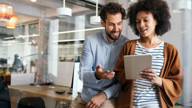 Happy couple looking at a digital device 