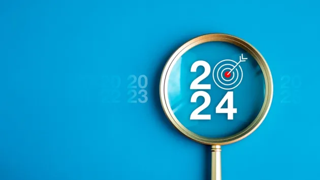 2024 and magnifying glass to depict business goals for 2024