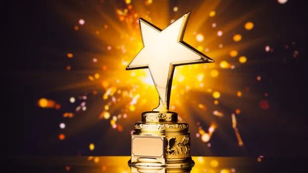 gold star trophy against shiny sparks background