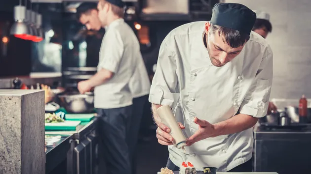 male cooks preparing sushi in the restaurant kitchen