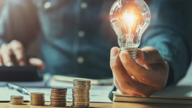 lightbulb and a stack of coins