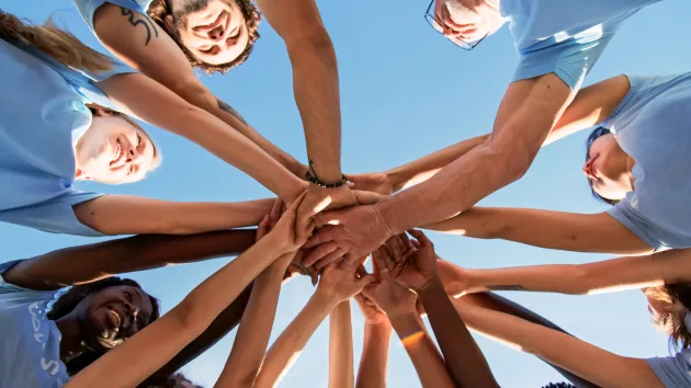 volunteers touching hands 