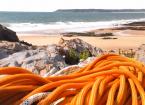 Ropes on a rock in front of a beach.