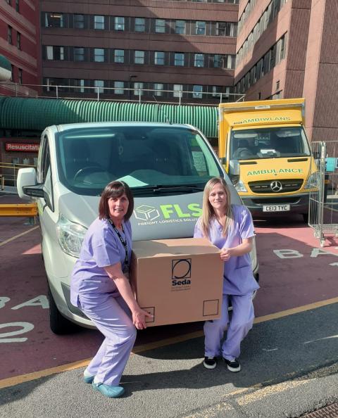 An FLS van outside a hospital and two nurses.