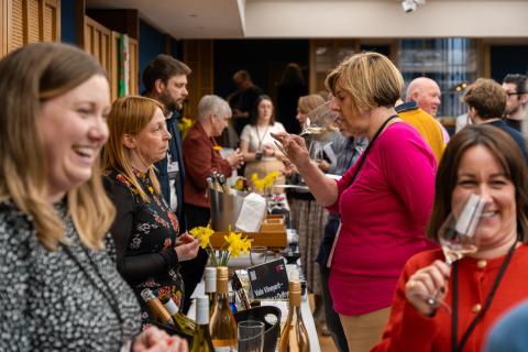 People and producers in a room tasting Welsh Wine