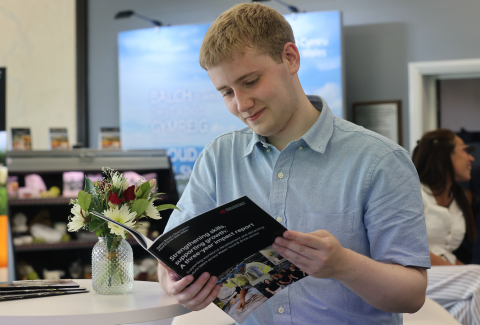 A student reading the three year impact report