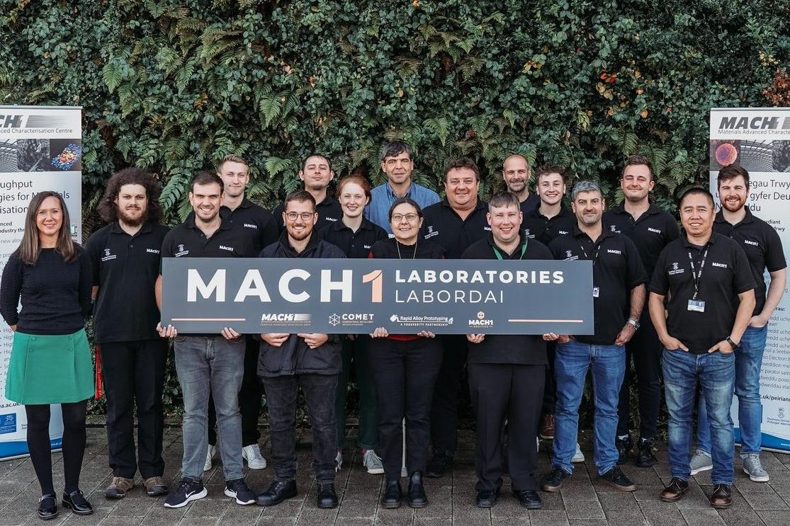 Group of people holding a MACH1 Laboratories sign 
