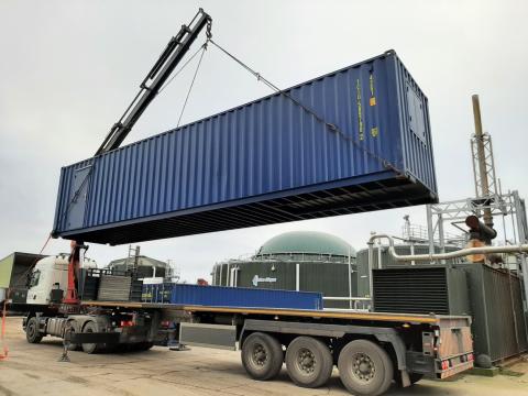Shipping container being loaded on to a truck for delivery