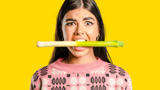 Woman biting a leek