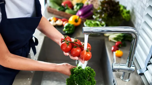 Kitchen staff washing vegetables for food prep