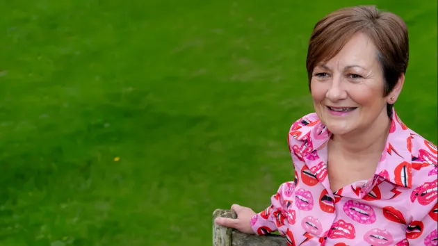 Lady sitting on a bench smiling 