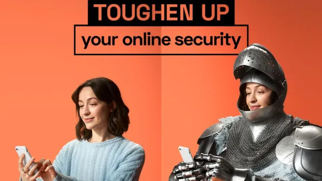 Cyber security - woman wearing a suit of armour looking at a digital device 