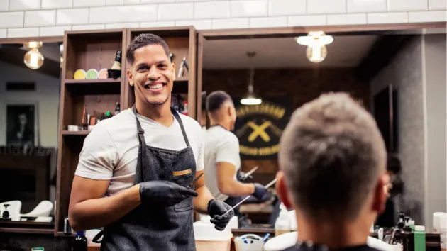 Barber - smiling cutting a customer's hair