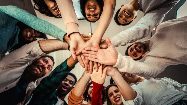 group of people touching hands 