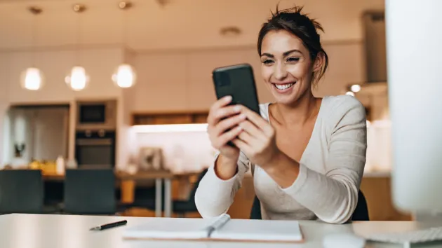 person looking at their mobile phone at work 