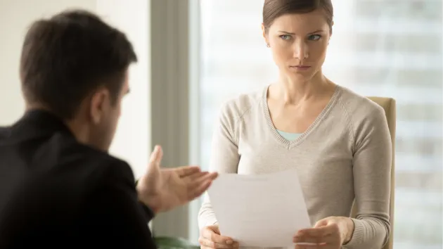 Sceptical business woman looking at a document 