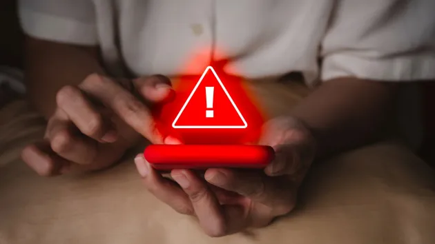 mobile phone and a warning sign in red 