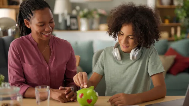 parent and teenager saving money in piggy bank 