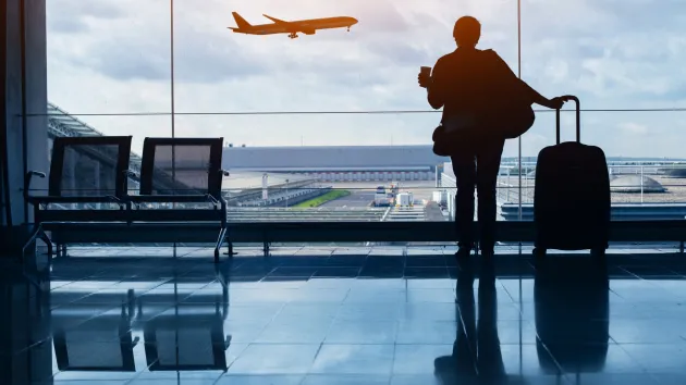 Person at an airport with a suitcase 