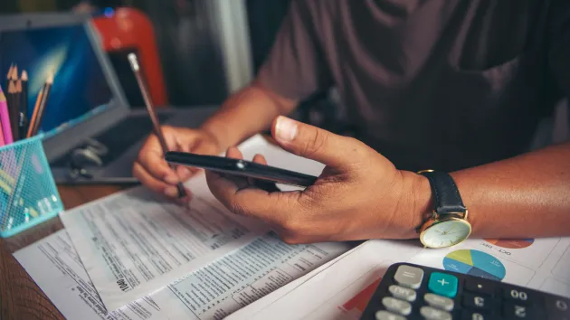 person using a calculator for tax purposes 